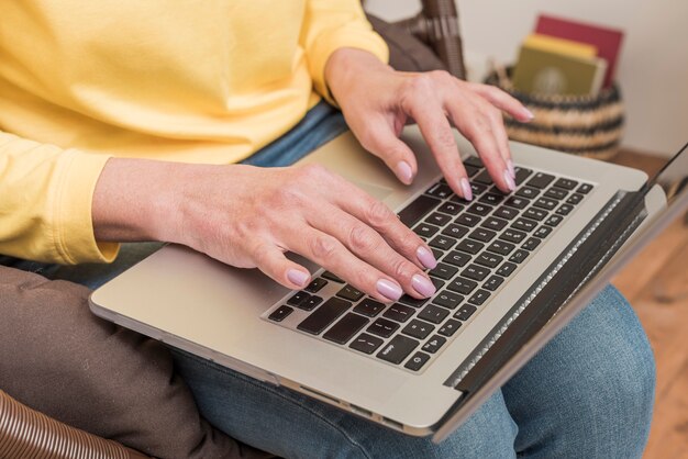 Donna senior che lavora al suo primo piano del computer portatile