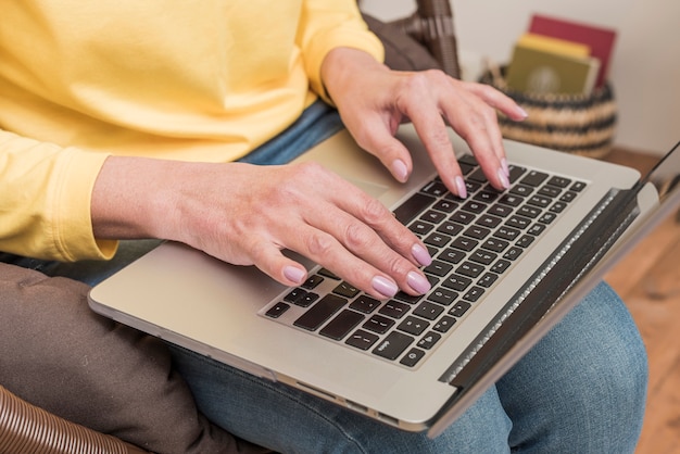 Donna senior che lavora al suo primo piano del computer portatile