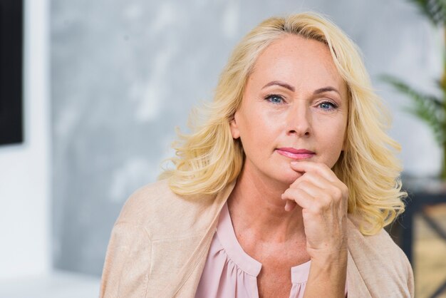 Donna senior con gli occhi azzurri che esaminano la macchina fotografica