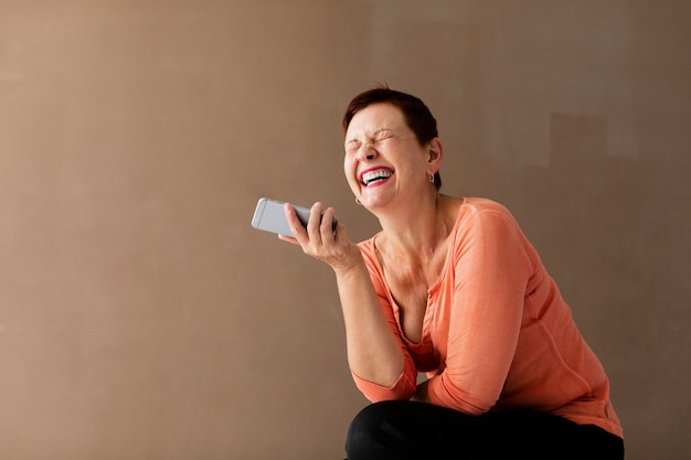 Donna senior con il telefono che si diverte