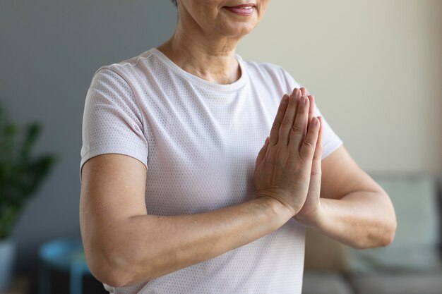 Donna senior del primo piano che pratica la meditazione