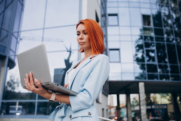 Donna senior di affari con il computer portatile dal centro dell'ufficio