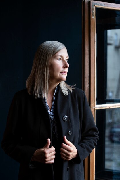 Donna senior di vista frontale che posa all'interno