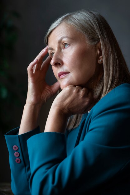 Donna senior di vista laterale che posa all'interno