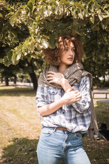 Donna sensuale che osserva via sotto l&#39;albero