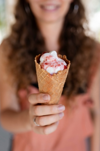 Donna sfocata vista frontale che tiene il gelato