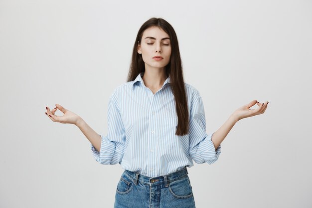 Donna sollevata con gli occhi chiusi che meditano, le mani lateralmente che fanno il gesto zen