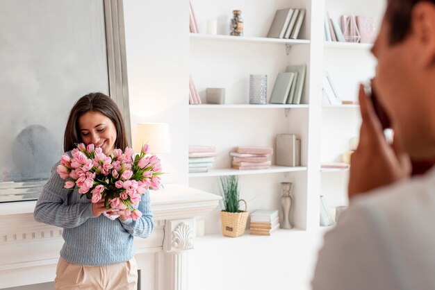 Donna sorprendente dell'uomo del primo piano con i fiori