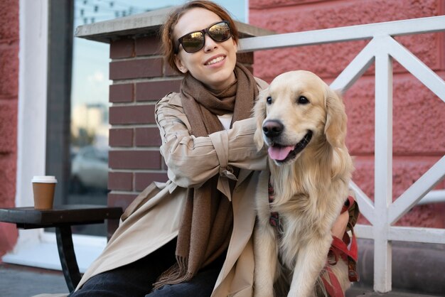 Donna sorridente a colpo medio che accarezza il cane