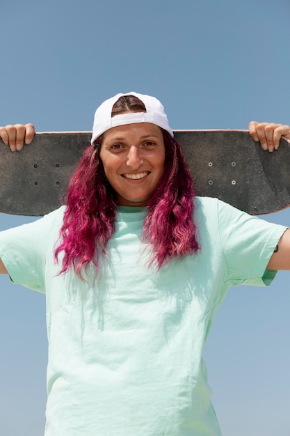 Donna sorridente a tiro medio con skateboard