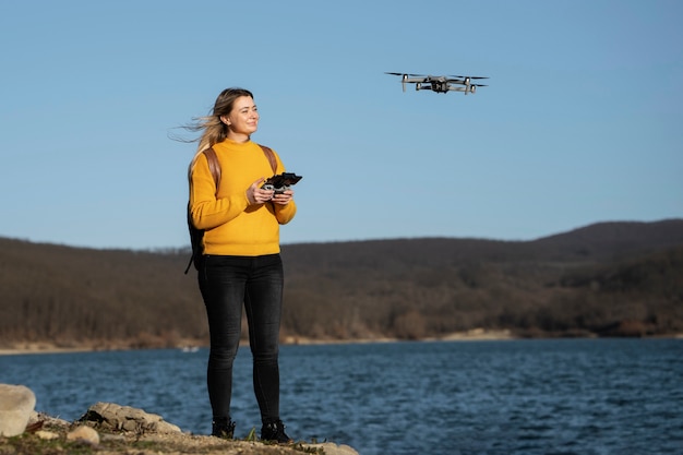 Donna sorridente a tutto campo con drone all'aperto