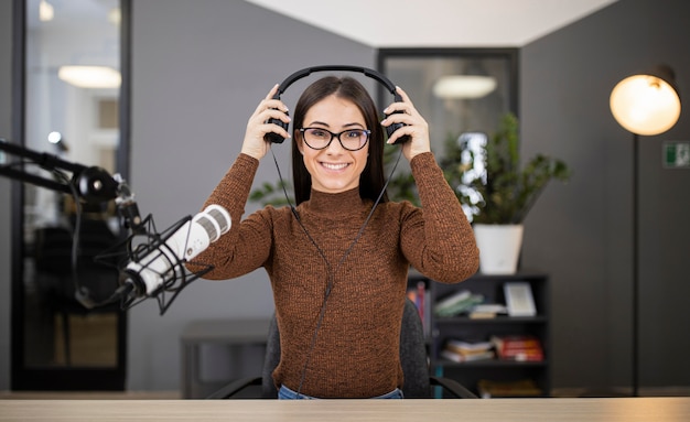 Donna sorridente alla radio con microfono e cuffie