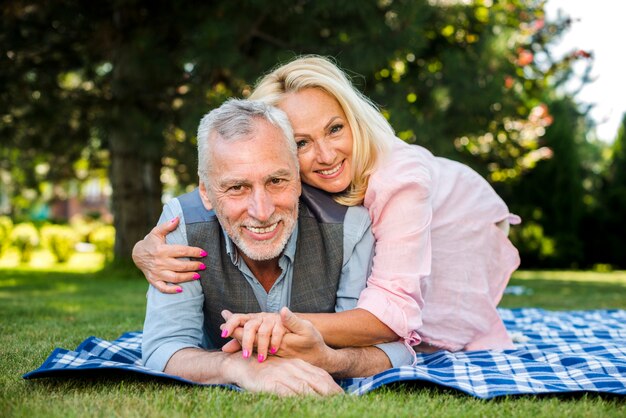 Donna sorridente che abbraccia il suo uomo al picnic