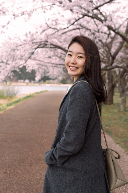 Donna sorridente che cammina nel parco