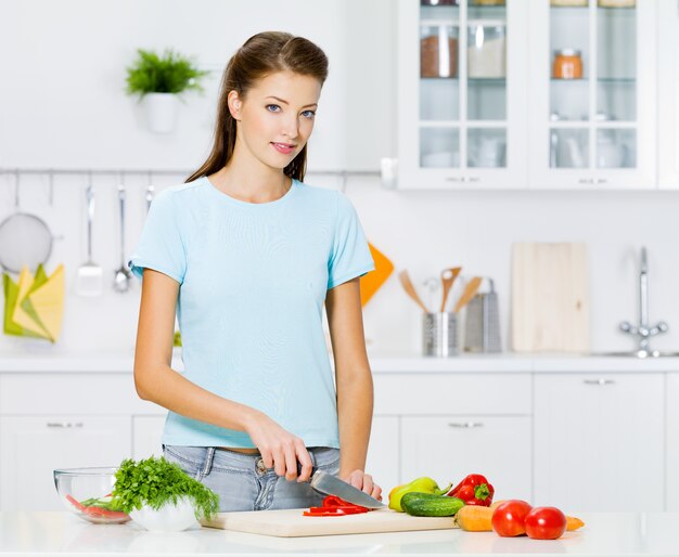 Donna sorridente che cucina cibi sani in cucina