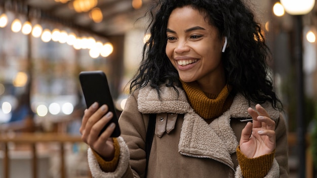 Donna sorridente che indossa gli auricolari per ascoltare la musica