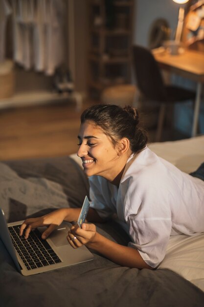 Donna sorridente che lavora al computer portatile dalla casa