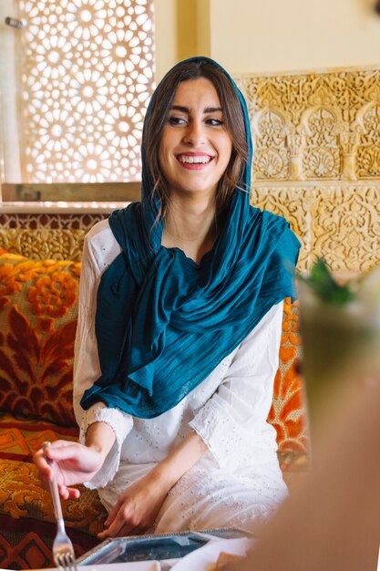 Donna sorridente che mangia nel ristorante arabo