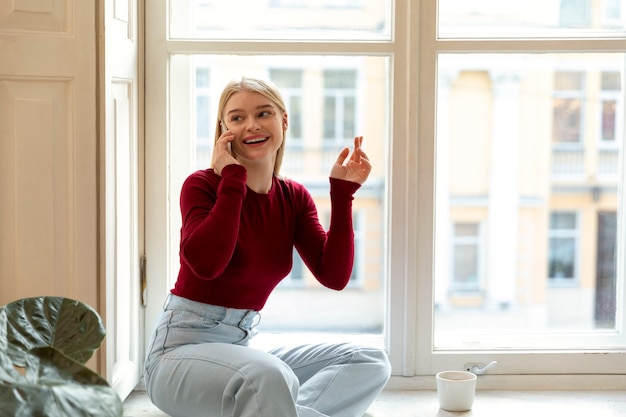 Donna sorridente che parla al telefono inquadratura media