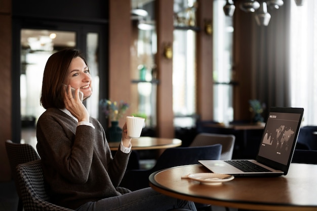 Donna sorridente che parla sulla vista laterale del telefono