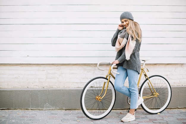 Donna sorridente che posa con la bicicletta