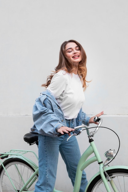 Donna sorridente che si siede sulla sua bici