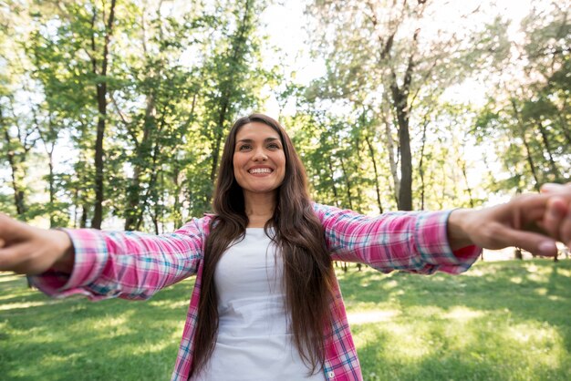 Donna sorridente che tira la mano del suo partner al parco