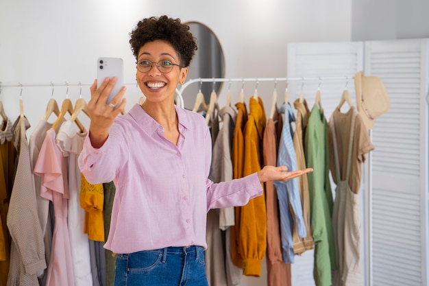 Donna sorridente che vende vestiti di colpo medio