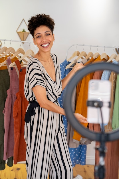 Donna sorridente che vende vestiti online vista laterale