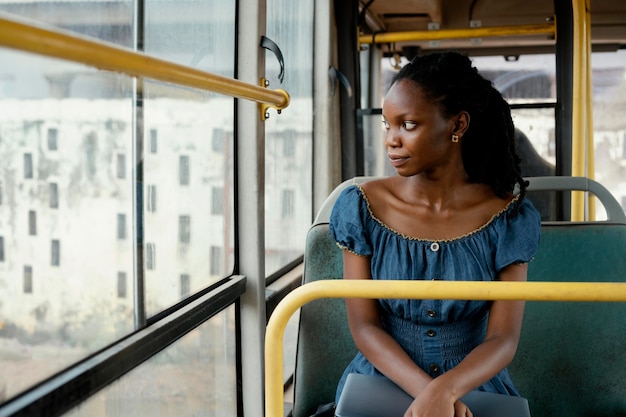 Donna sorridente che viaggia in autobus colpo medio