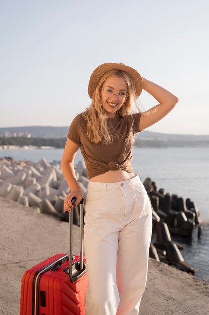 Donna sorridente con cappello e bagagli