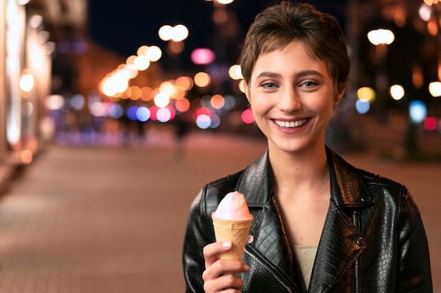 Donna sorridente con colpo medio che tiene il gelato