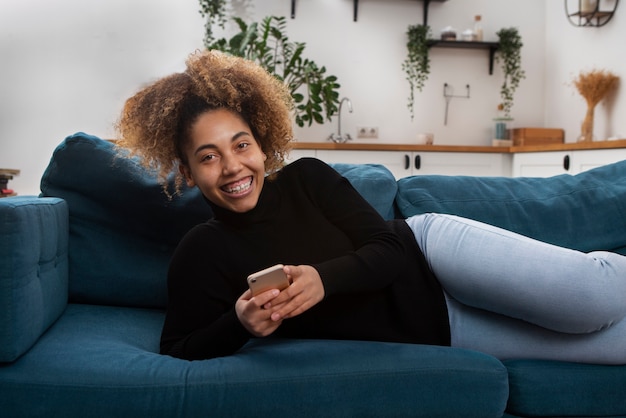 Donna sorridente con colpo medio sul divano