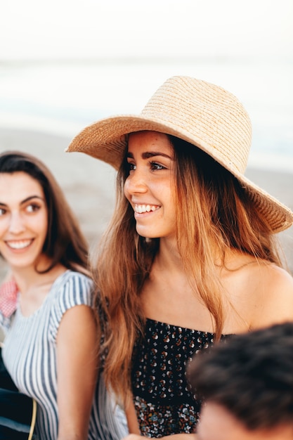 Donna sorridente con i suoi amici in spiaggia