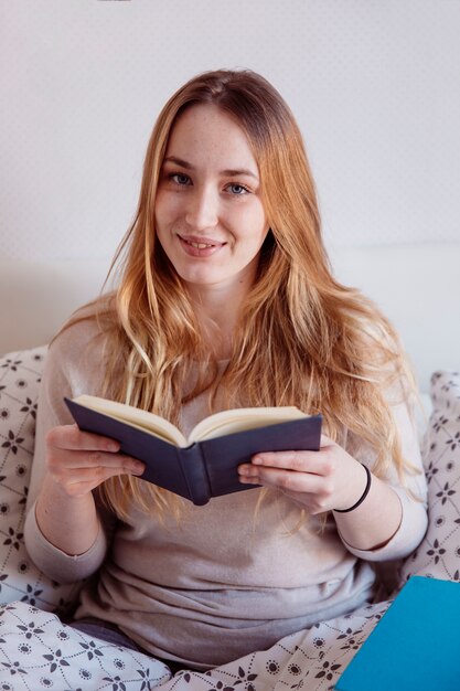 Donna sorridente con il libro