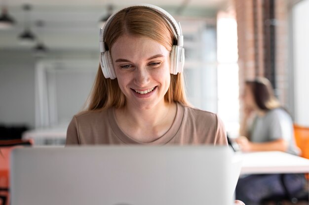 Donna sorridente con tiro medio che indossa le cuffie