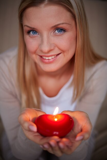 Donna sorridente con una candela a forma di cuore