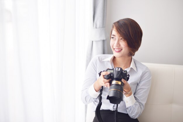 Donna sorridente con una macchina fotografica reflex