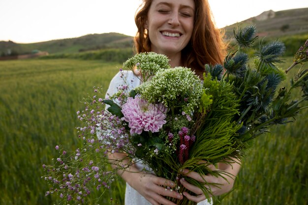 Donna sorridente con vista frontale del mazzo di fiori