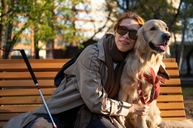 Donna sorridente del colpo medio che abbraccia cane