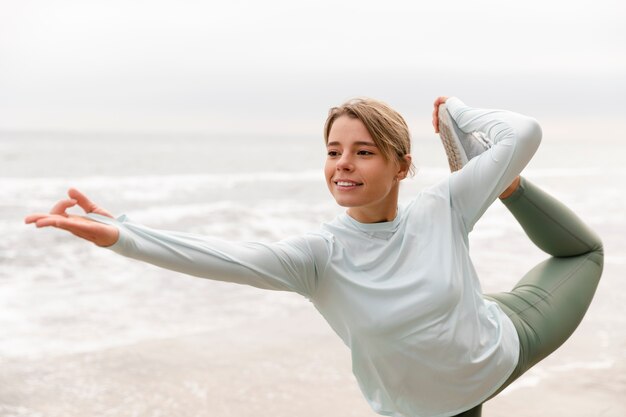 Donna sorridente del colpo medio che fa yoga