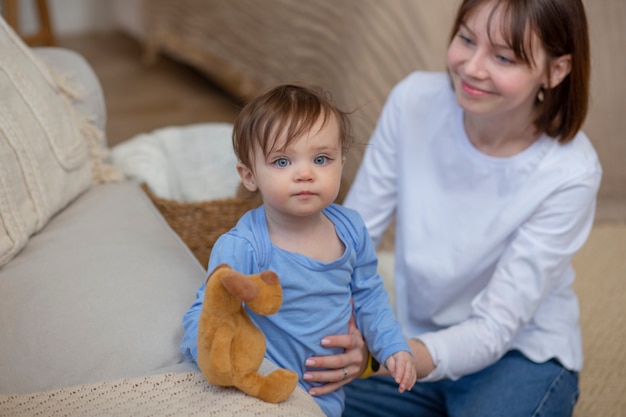 Donna sorridente del colpo medio che gioca con il bambino