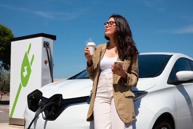 Donna sorridente del colpo medio che gode del caffè