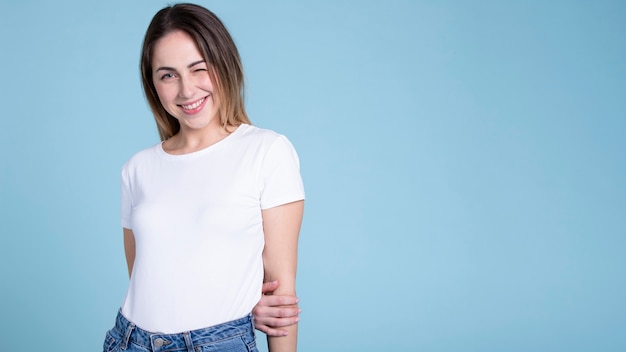 Donna sorridente del colpo medio che porta camicia in bianco