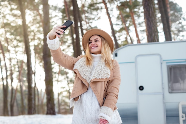 Donna sorridente del colpo medio che prende selfie