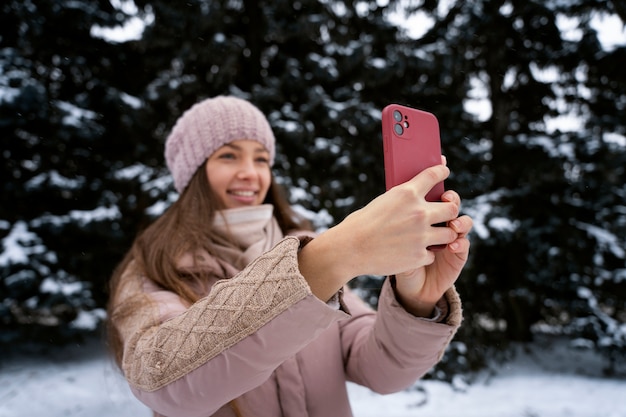 Donna sorridente del colpo medio che scatta foto