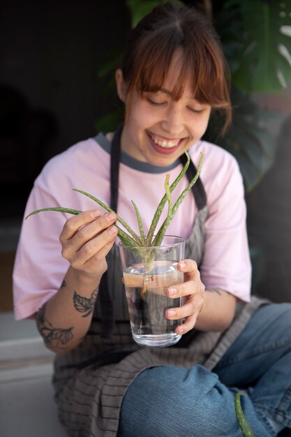 Donna sorridente del colpo medio che tiene il bicchiere d'acqua