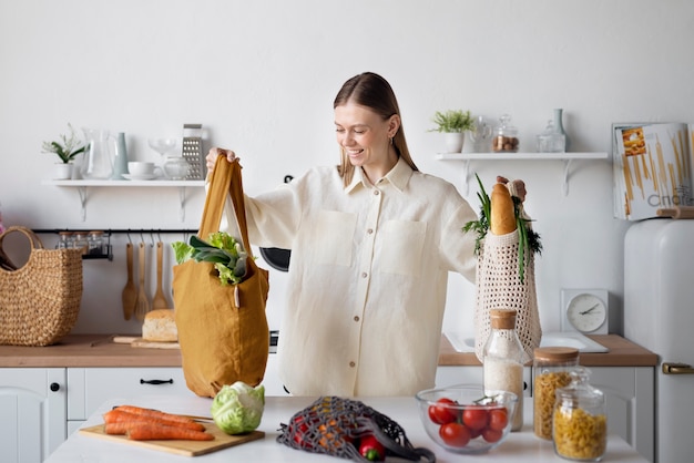 Donna sorridente del colpo medio con generi alimentari