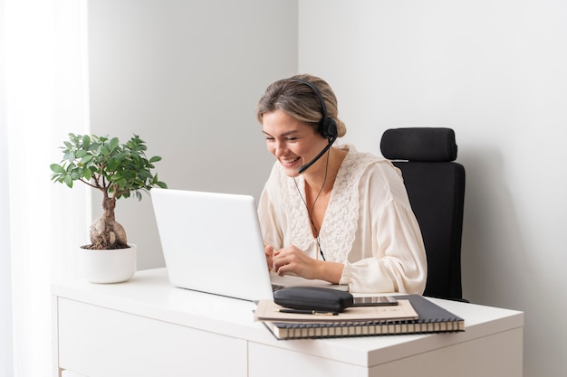 Donna sorridente del colpo medio con il computer portatile