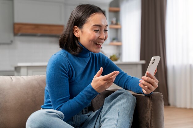 Donna sorridente del colpo medio con il dispositivo